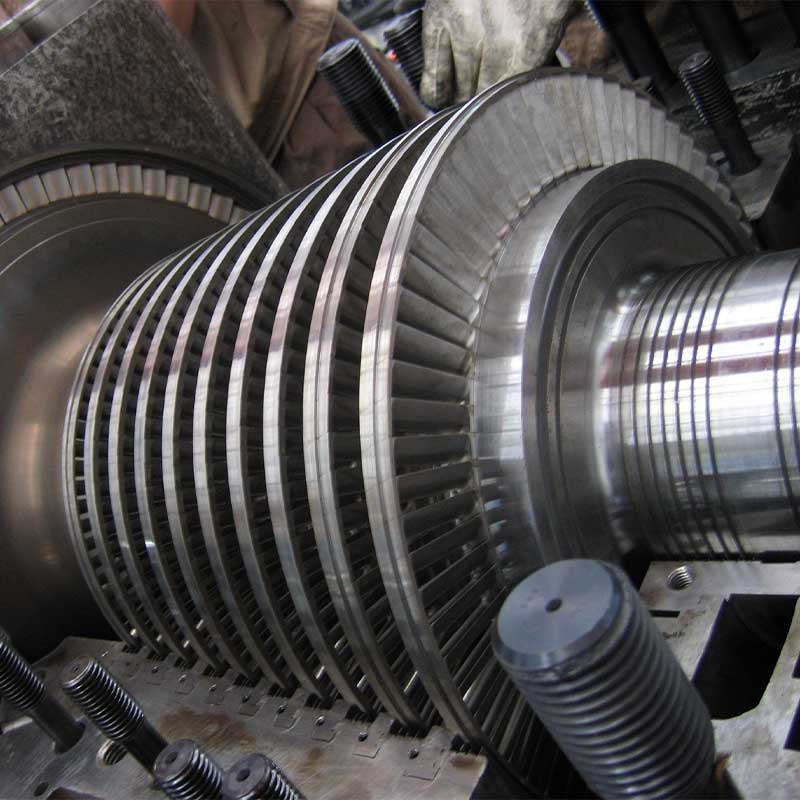 person using crane to move industrial gear box in engineering factory